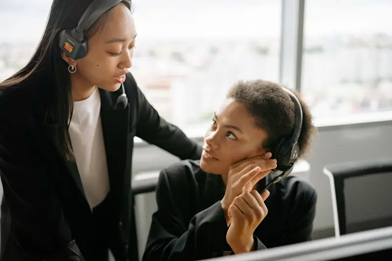 Experienced advisor providing guidance to team member at workstation — knowledge transfer and quality assurance in delivery process — AI-augmented consulting capability building