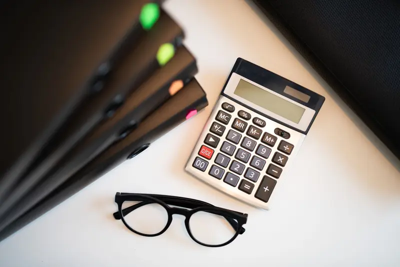 Service agreement document with writing instrument and calculation tools — detailed SOW being reviewed for pricing and cost structure — consulting engagement terms